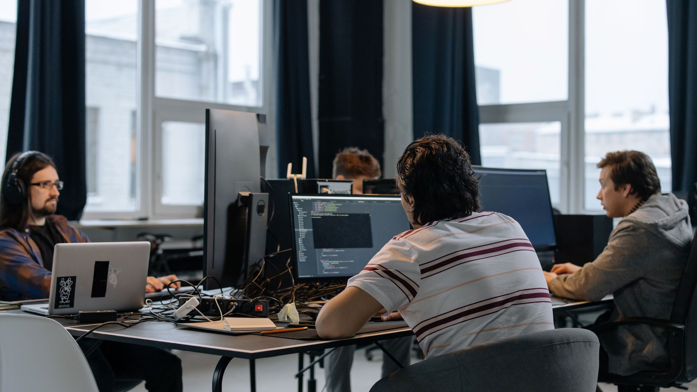 Software developers working together at monitors in a modern office